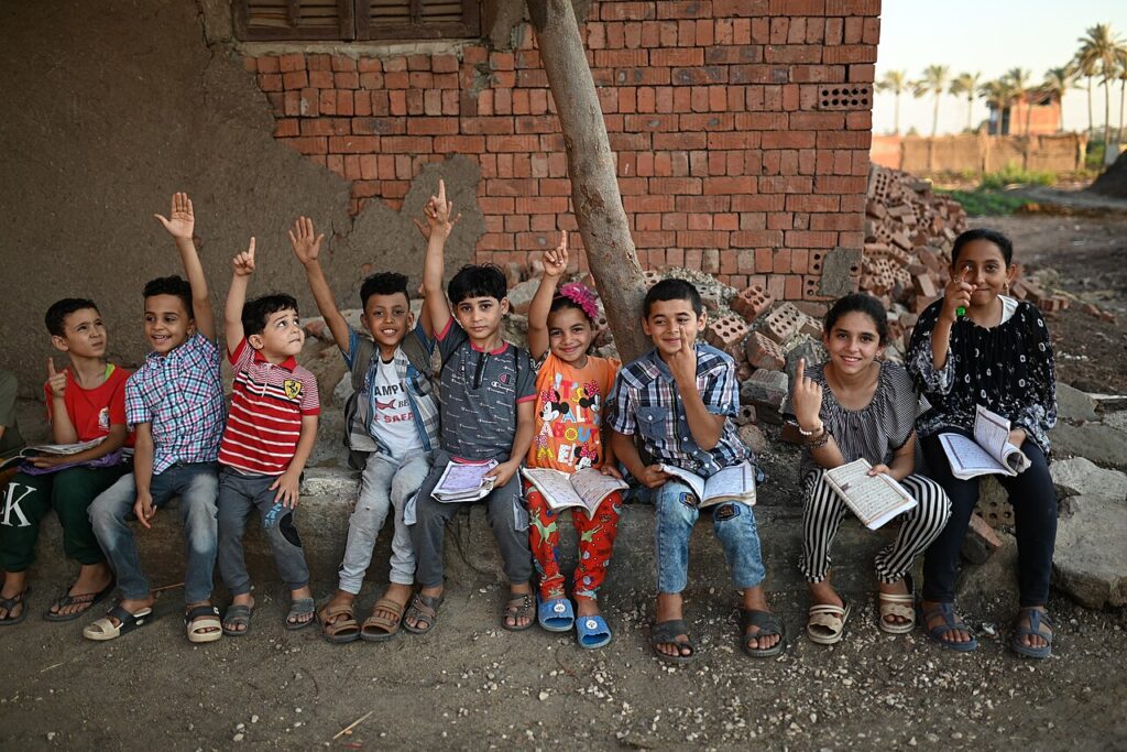 Strong Quran memorization – students raising their hands, ready to recite